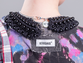 Фото ярлыка бренда Verushka и массивным черным украшением на шею.